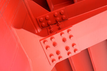 The red iron beam is bolted down. Close-up shows the connection of the steel powerful straight...