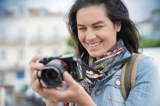 Portrait of woman reporter taking pictures with reflex camera