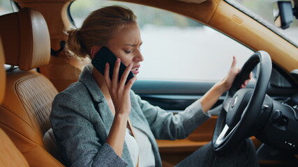 Side view of businesswoman talking phone at car. Woman leaning on steering wheel