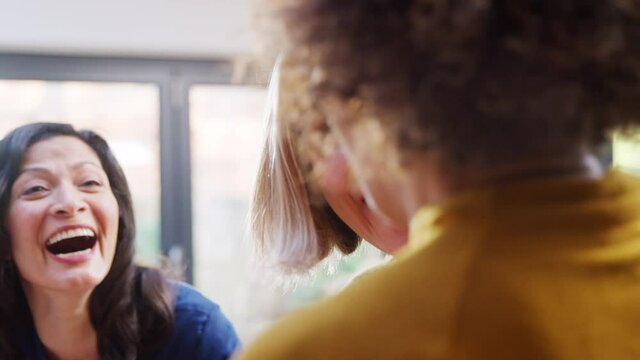 Group of mature female friends meeting at home talking and drinking wine together - shot in slow motion