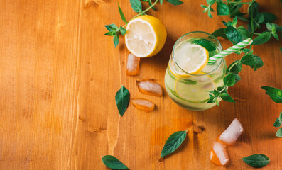 Refreshing summer detox lemonade with cucumber, lemon and mint in a glass on a wooden table top view