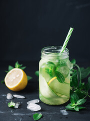 Fototapeta premium Close-up detox water with cucumber, mint and lemon in a jar . Summer cold healthy drink
