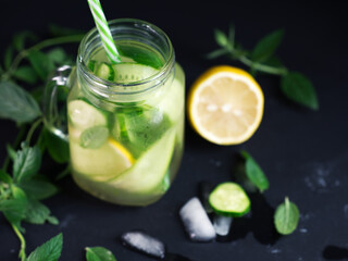 Close-up detox water with cucumber, mint and lemon in a jar . Summer cold healthy drink