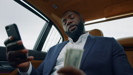 Closeup african man making video call at car. Afro man shaking money at backseat