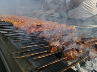 Shashlik preparing on a barbecue grill over charcoal. Shashlik or Shish kebab popular in Eastern Europe.