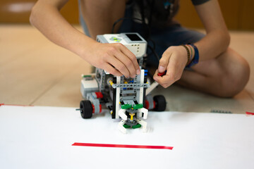 Ni&ntilde;o construyendo un robot en una clase escolar de rob&oacute;tica