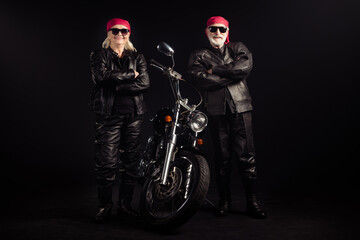 Fototapeta na wymiar Full length photo of aged bikers man lady couple drive chopper travel feel young rock moto festival arms crossed wear rocker leather outfit sunglass bandana isolated black color background