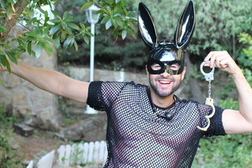 Attractive man wearing bunny mask holding handcuffs