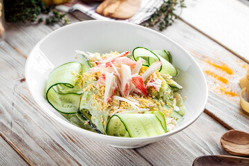 Salad with sliced cucumber ground eggs and crab