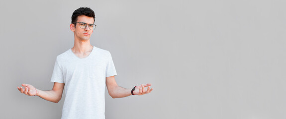 Closeup portrait of dumb clueless young man, arms out asking what's the problem who cares so what, I don't know. Isolated on white background. Negative human emotion, facial expressions, attitude