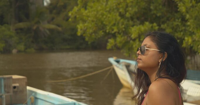 A pretty east indian model wearing sunglassess and hoop earings while in a protected wetland