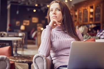 Woman works remotely online from cafe while quarantine coronavirus is in effect. Concept of checking mail, blogger, freelancer