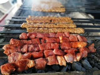 Shashlik preparing on a barbecue grill over charcoal. Shashlik or Shish kebab popular in Eastern Europe.