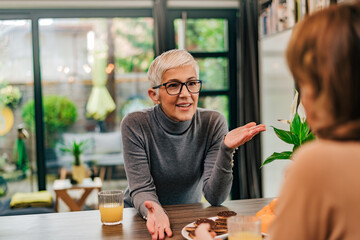 Modern mature woman discussing with a friend, portrait.