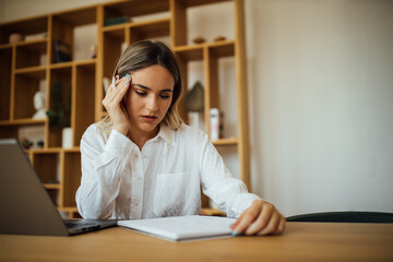 Portrait of a worried young woman studying or reading.