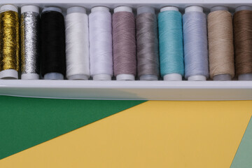 Composition of a flat layer with colored sewing threads on a multicolored background