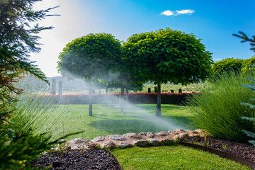 Wedding garden on a sunny day and the sprinklers watering.