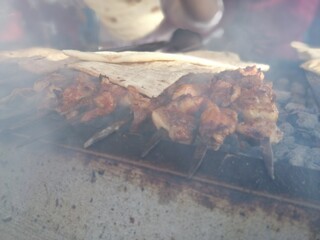 Shashlik preparing on a barbecue grill over charcoal. Shashlik or Shish kebab popular in Eastern...