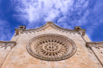 Fototapeta premium Cathedral Assumption of the Virgin Mary in old town Ostuni (Puglia, Italy): detail of the rose window in the main facade.