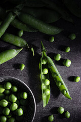 Fresh homegrown green peas in moody dark photography