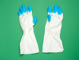 Fototapeta premium white protective rubber gloves on a green background