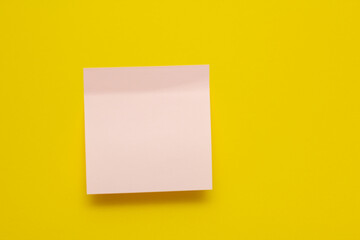Pink sticker on a yellow background. Sticker with a sticky edge. Sticker for inscriptions. Copy space.