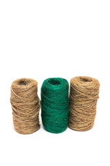 Three skeins of twine. Twine. The twine is brown and green. On a white background, string