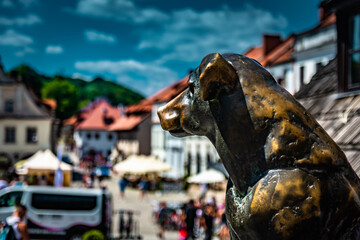 Copper dog against the background of the old market in Kazimierz Dolny.