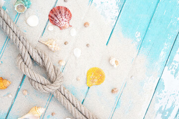 pattern sea shell and rope on a blue old wooden background with sand. Summer time holiday concept. Top view. Leave a copy space for writing descriptive text. tone colorful pastel.