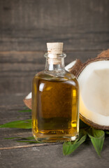 Ripe half cut coconut with green leaves on a wooden background.