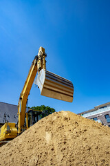 Gelber Bagger mit Baggerschaufel für Sand