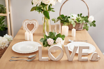 Wedding invitation card. Romantic candlelight dinner. Wedding table decor. Valentine's Day 14th of February. Background with flowers roses and peonies. Festive table setting. Wedding decor