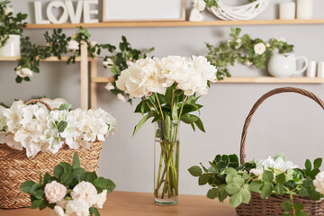 Floral background. Flower shop interior. Floral design studio, making decorations and arrangements. Flowers delivery service and sale of home plant, creating order. Peonies and roses.
