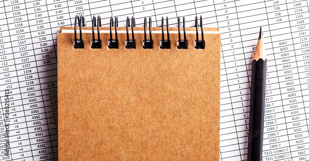 Poster the report contains a brown notepad and a black pencil. copy space. top view close up