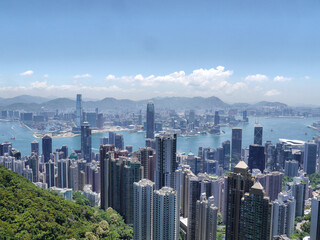 Fototapeta na wymiar Hong Kong Skyline With Tall High Rise Skyscraper Buildings, Victoria Harbour and Mountains - View From Victoria Peak (Kowloon and Hong Kong Island)
