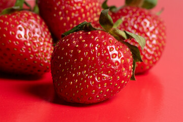 bright juicy ripe strawberries on a red background. Front view, healthy food, vegetarianism