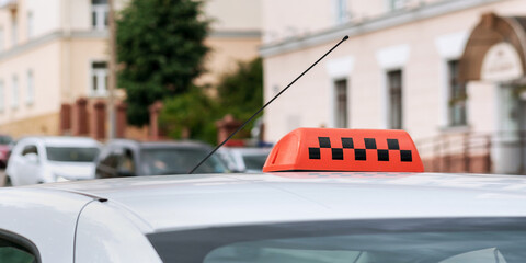 orange bright taxi sign on roof of cab vehicle at city street