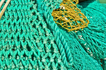 A heap, a huddle of traditional fishing equipement with green nets and orange buoys