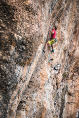 Climber overcomes a difficult climbing route on a natural terrain.