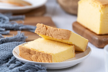 Plain classic Taiwanese traditional sponge cake (Taiwanese castella kasutera) on a wooden tray background table with ingredients, close up.