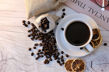coffee cup and coffee beans on old wood table background, space for text