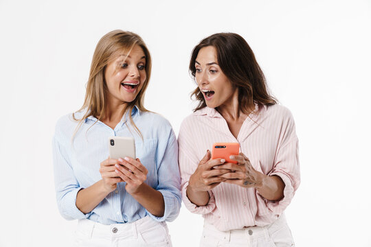 Image of beautiful excited two women using mobile phones