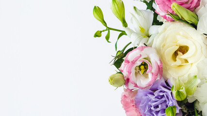 bouquet of pink, lilac and white eustomas, copy space for text on the left on a white background