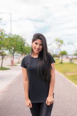 Mulher jovem e bonita sorrindo posando para a câmera depois da corrida olhando para a câmera.