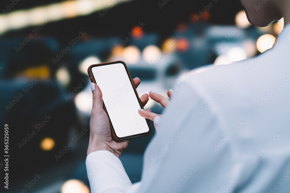 Poster cropped back view of young woman typing with finger on blank display of modern smartphone on bokeh b