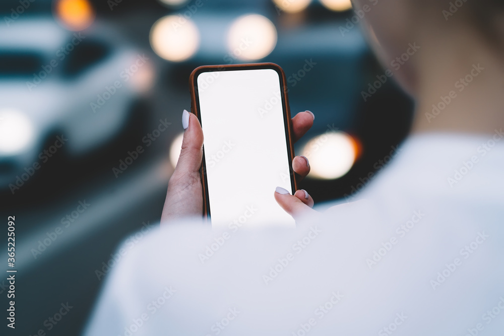 Aufkleber cropped back view of woman holding digital smartphone in front of yourself and touching with finger 