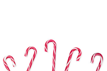 Christmas candy canes at the bottom of the frame on a white isolated background white / red Christmas candies. Space for text