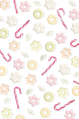 Meringue and Candy canes on a white isolated background Multiple colored green / orange / white / red and pink Christmas candies, lie in a pattern