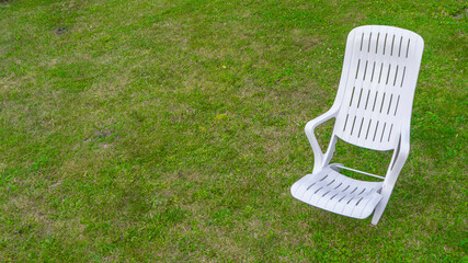 White chaise lounge on green grass. recreation concept.