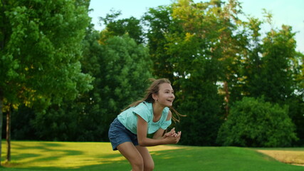 Smiling girl throwing ball in air outdoors. Happy man catching ball in field